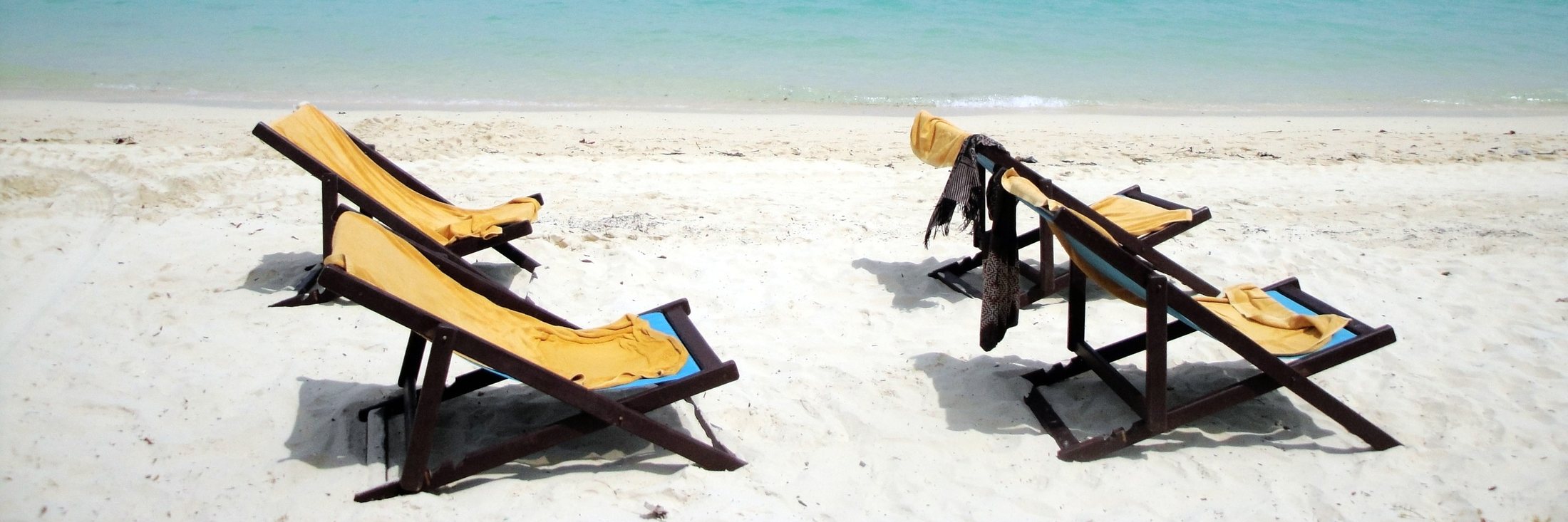 Deckchairs on a white-sand beach by a turquoise sea, Thailand