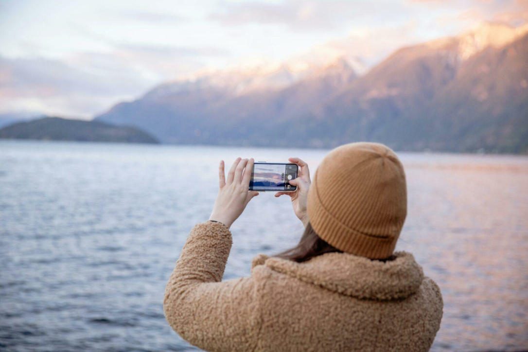 Traveller photographing a mountain lake